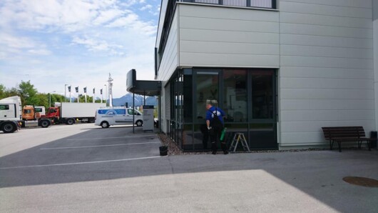 Produktfoto Glaswand Foto zeigt einen Mitarbeiter von Glasreinigung Reischenbeck bei Reinigung der Hausfassade